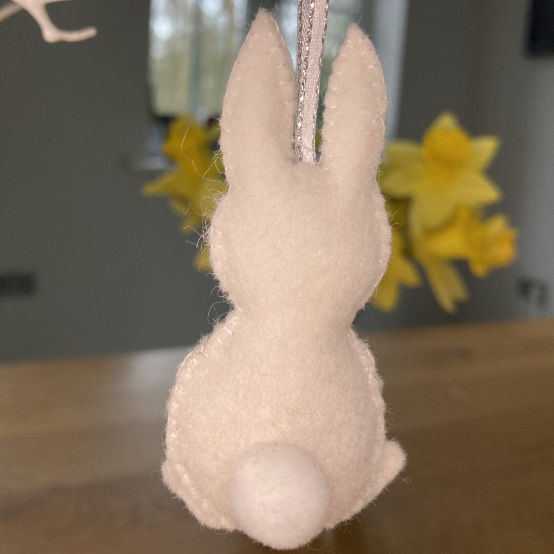 The back of the bunny has a large white pom pom tail
