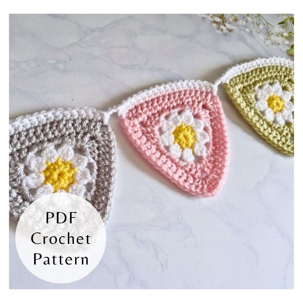 Digital PDF crochet pattern for triangle daisy bunting. Includes step-by-step photos and clear instructions for intermediate crocheters. Close up of crochet daisy triangle flag with petal detail
