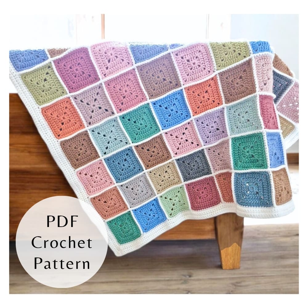 A colourful crochet square blanket made from scrap yarn, showcasing the textured joining and border of the PDF pattern.