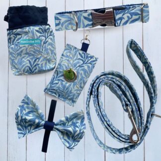 Flat lay of handmade dog accessories in William Morris design. Items are a dog collar, lead, bow tie, treat pouch and poo bag pouch in sea breeze blue.