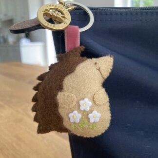 Handamde felt hedgehog with a velvet ribbon attaching it to a slip ring so it can be attached to a bag