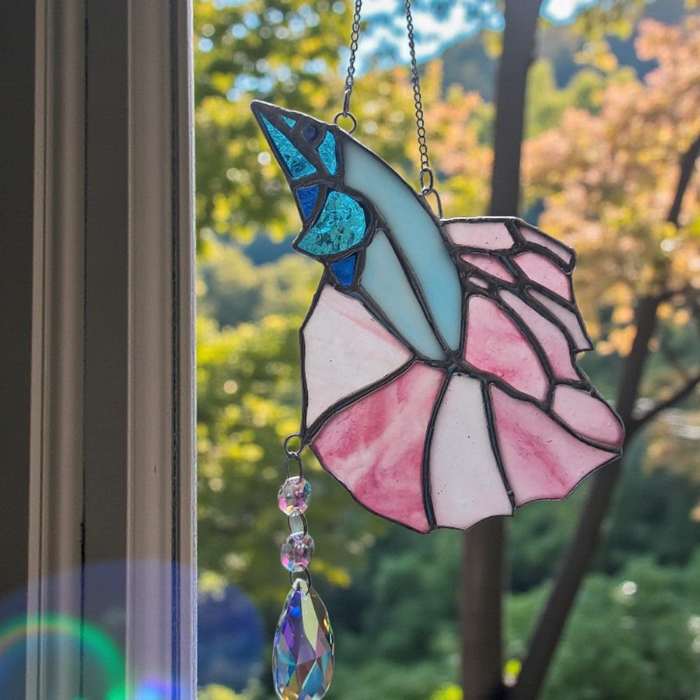 Artisan handmade stained glass fish with iridescent pink body and turquoise accents, finished with colourful rainbow prism