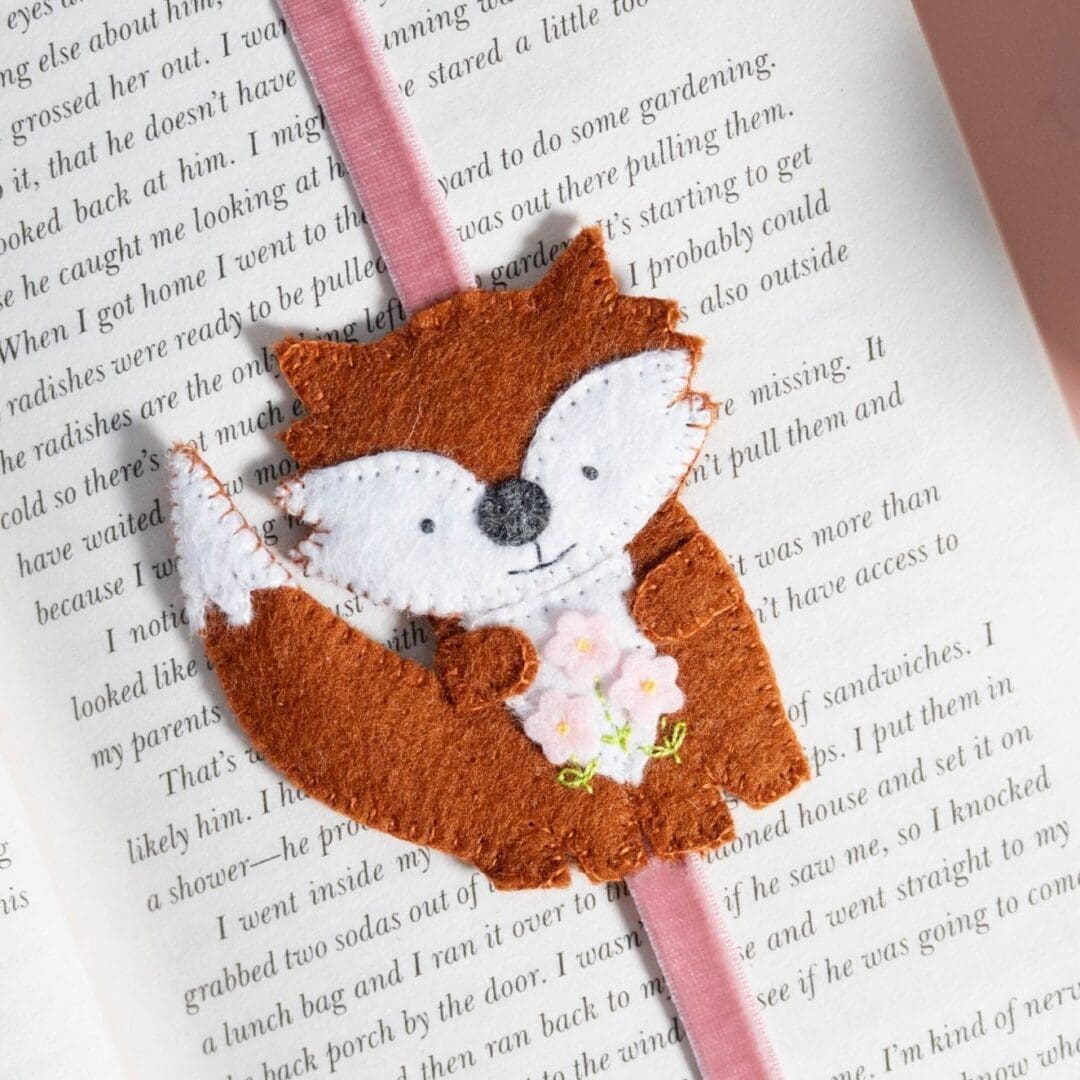 Close up of my hand sewn little fox which is attached to a pale pink velvet stretchy ribbon
