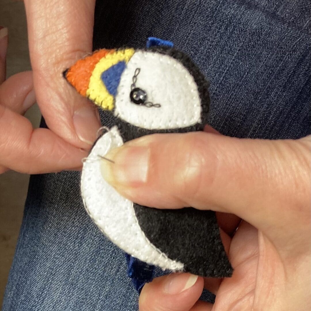 Close up of me sewing the felt puffin by hand