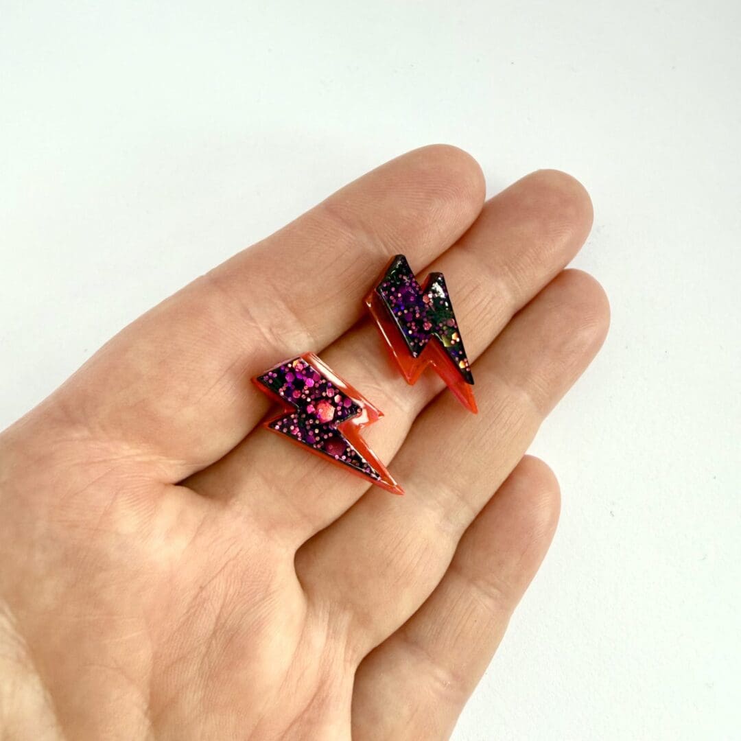 Statement lightning bolt earrings shown for size on hand