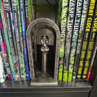 A metal book nook, or book seperator with a dragon satinbetween 2 arches. Hand forged from steel.