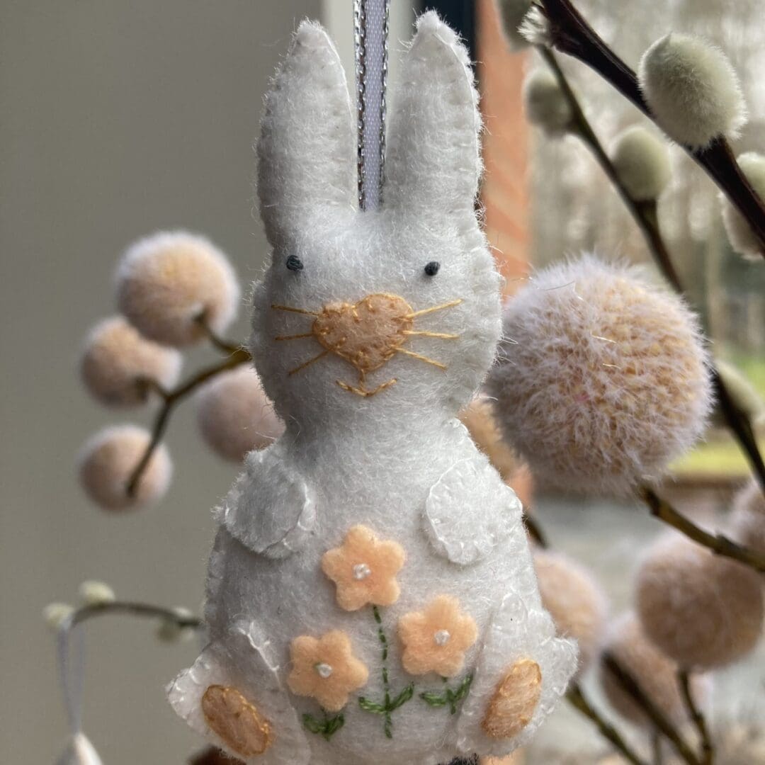 Handmade white bunny with peach flowers, nose, whiskers and paws