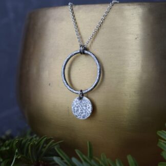 solid sterling silver pendant of hammered circles hung on a chain