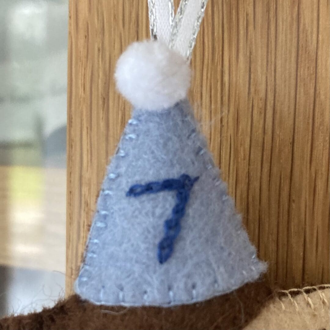 This blue hat is hand embroidered in dark blue with a number 7