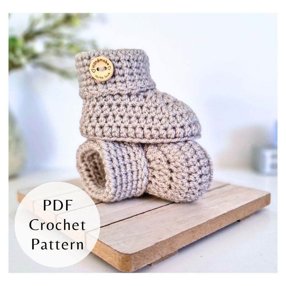 A digital PDF crochet pattern for baby button booties displayed in silver with wooden buttons.
