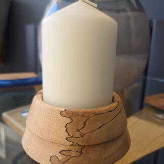 Handcrafted flaming beech candle holder with natural grain holding a white pillar candle