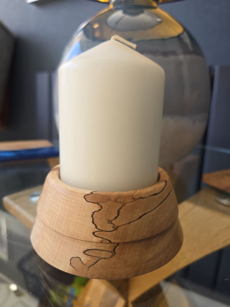 Handcrafted flaming beech candle holder with natural grain holding a white pillar candle