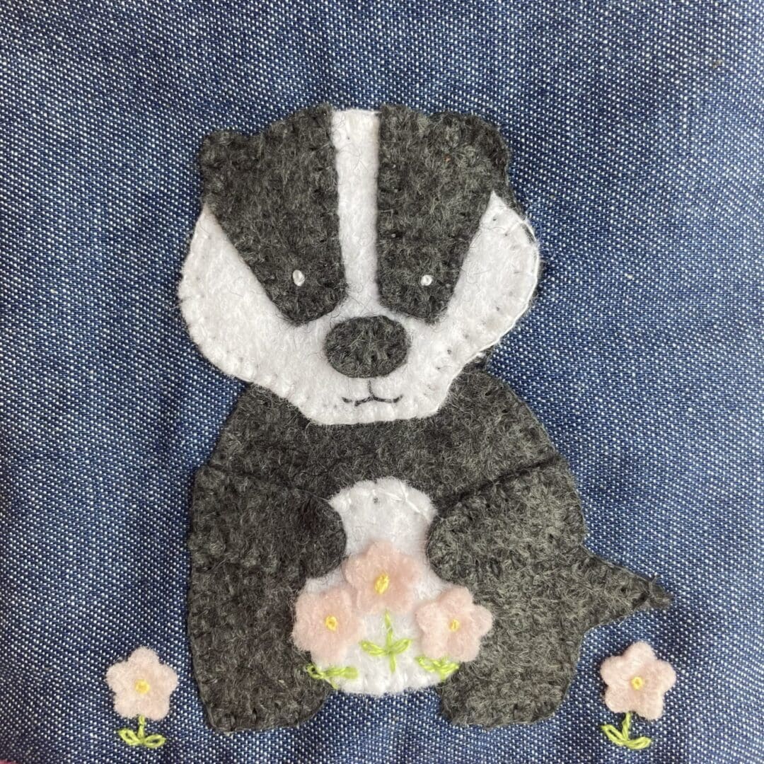 Close up of hand sewn felt badger on the glasses case