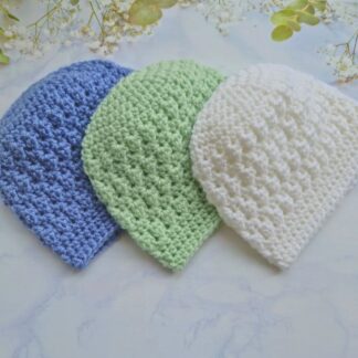 A soft, handcrafted crochet baby beanie hat in white, tea green and periwinkle blue featuring a classic textured stitch and a smooth trim.