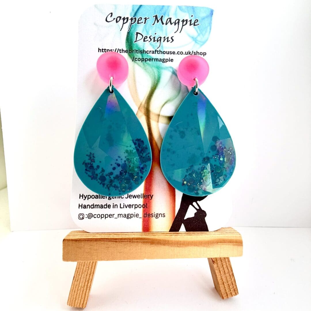 Holographic teardrop earrings on stud toppers shown on a branded Copper Magpie Designs card.