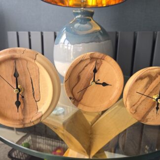 Handcrafted flaming beech mantle clocks in three sizes, shown as a collection