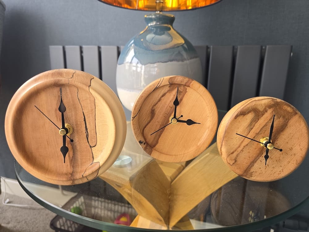 Handcrafted flaming beech mantle clocks in three sizes, shown as a collection