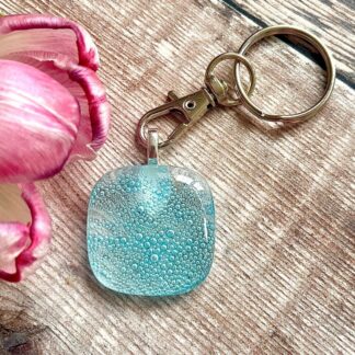 Clear fused glass keyring with blue bubbles within