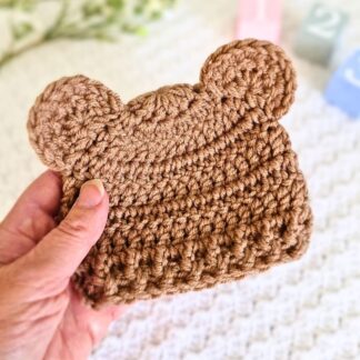 Handmade crochet baby beanie hat with cute teddy bear ears in a rich mocha finish.