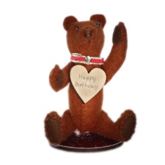 little felt bear in dark brown with a birthday message from its heart