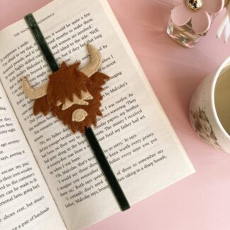 Felt highland cow face sewn on to a moss green velvet ribbon to hold your place in a book