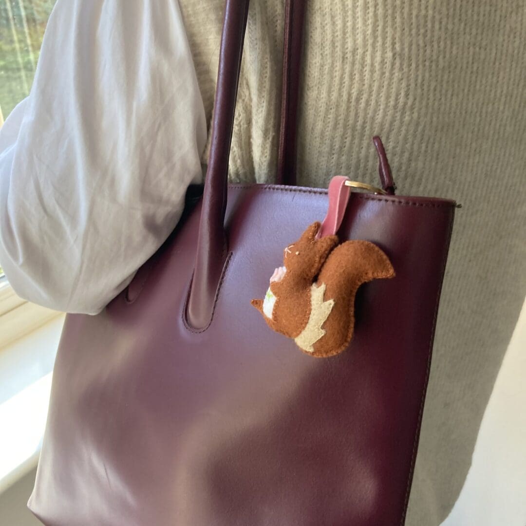 Handmade squirrel bag charm on my bag being carried on my shoudler
