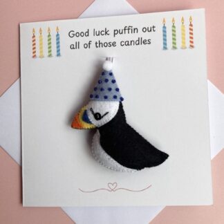 Personalised puffin birthday card with removable handmade felt puffin decoration. The puffin is black and white with a pale blue party hat. The puffin has a bright peak and a sequin eye