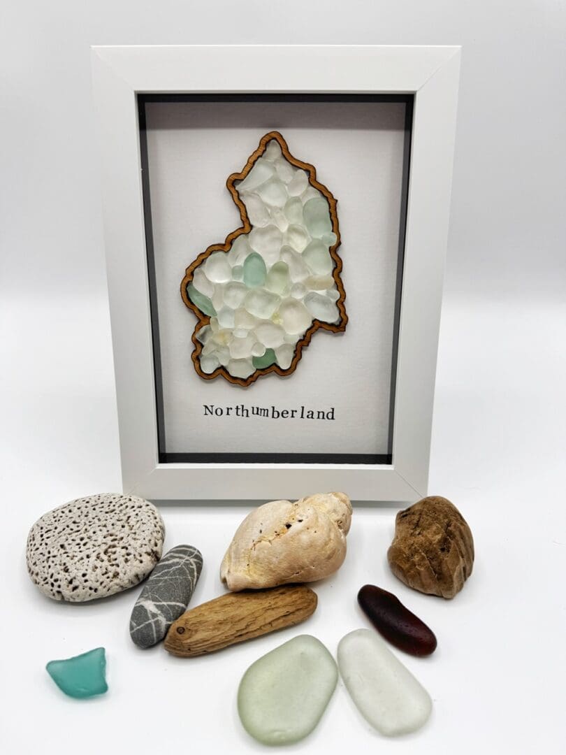 5x7 white frame showing outline of county Northumberland filled with sea glass pieces