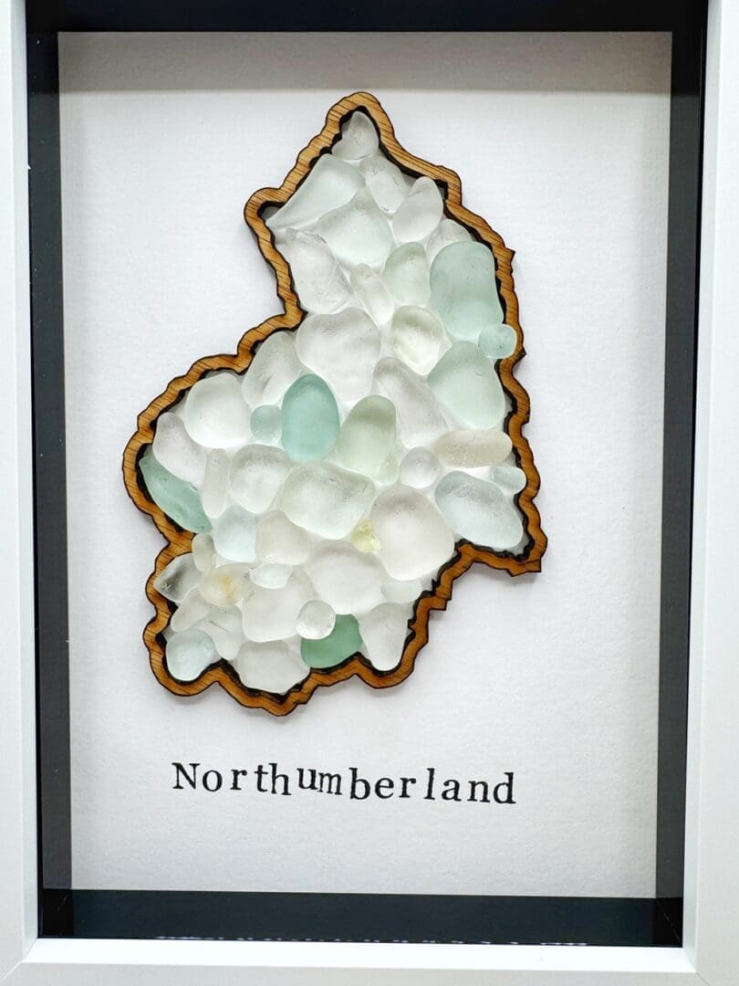 5x7 white frame showing outline of county Northumberland filled with sea glass pieces