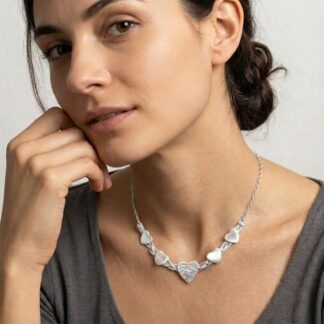 Five hearts woven necklace shown worn by a brunette model