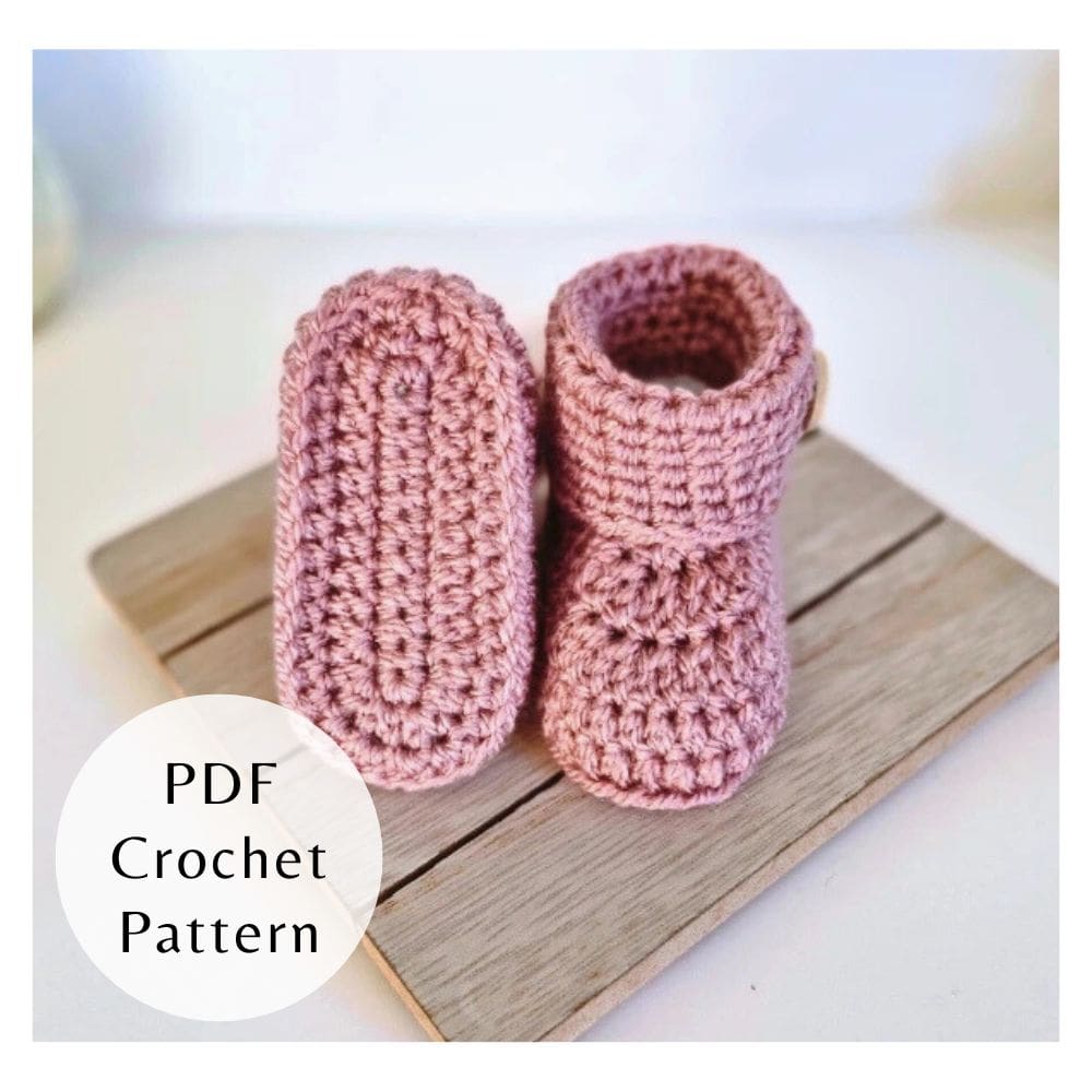 A digital PDF crochet pattern for baby button booties displayed in pink with wooden buttons.