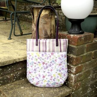 Quilted floral tote with purple leather handles