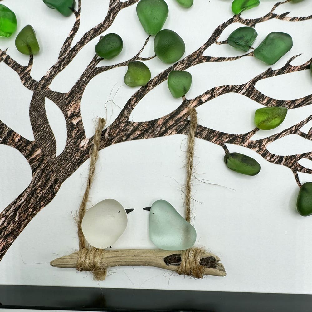two birds on a swing hanging from a tree