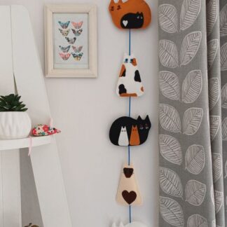Cats and kittens felt hanging decoration by lyndawilcansew hung against a wall beside a shelf unit and a picture of butterfles picture of butterflies showing the front of the decoration
