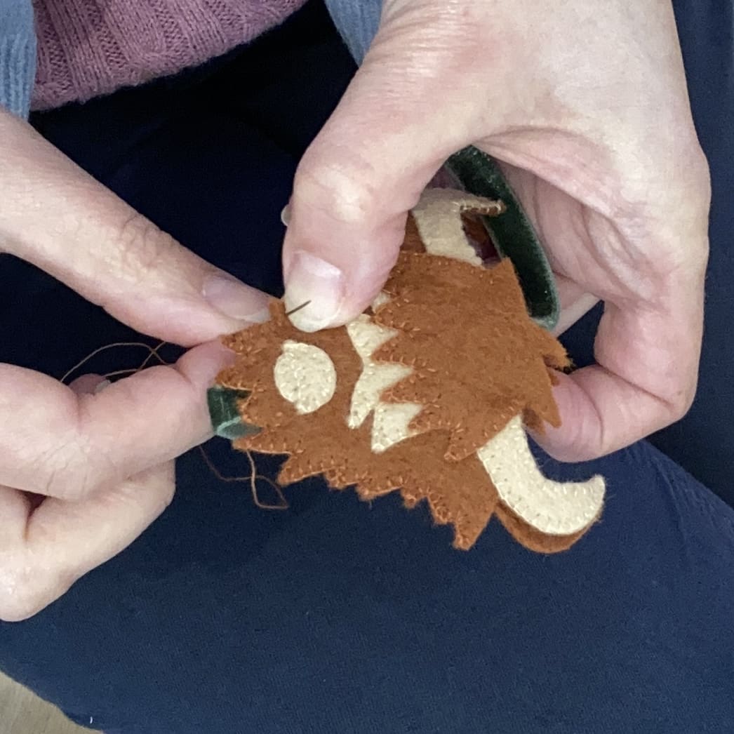 Hand sewing the felt highland cow