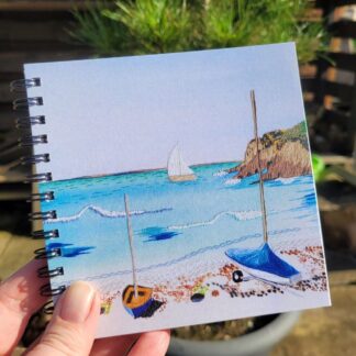 Notebook, 5x5inches. Featuring a print of embroidery of Little Haven Beach, ring bound.