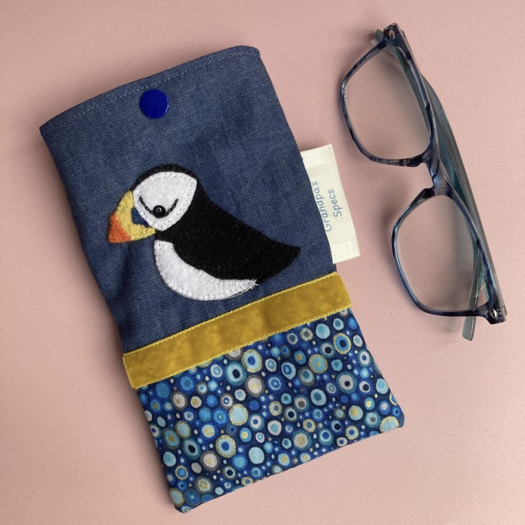 Puffin Glasses Case beside a pair of reading glasses