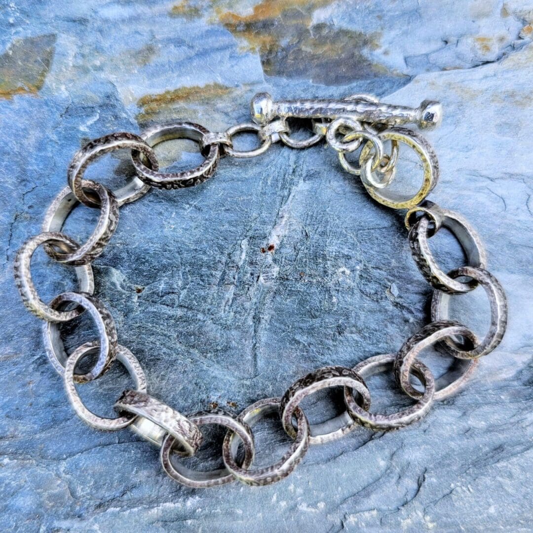 Chunky silver chain bracelet with hand etched leafy patterns and a forged toggle clasp, antique finish, Isobel Kelly Jewellery