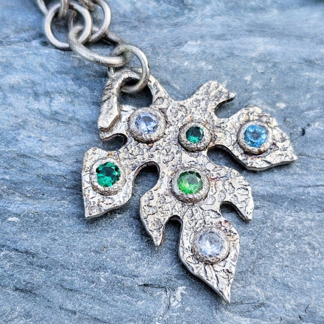 Silver leaf pendant set with lab emerald, topaz, tsavorite and spinel, Isobel Kelly Jewellery