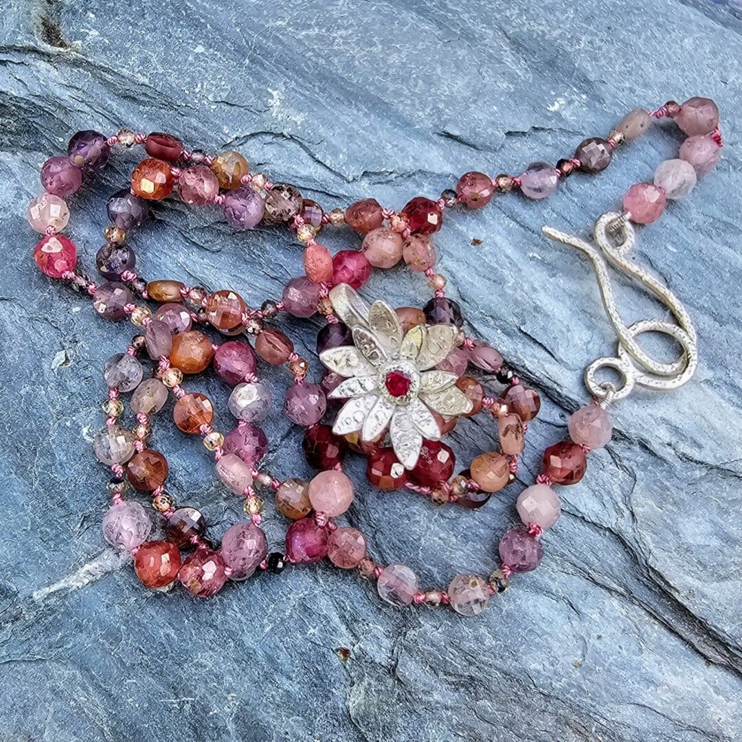 Spinel bead necklace with an etched silver flower pendant set with a small lab ruby at the centre, Isobel Kelly Jewellery