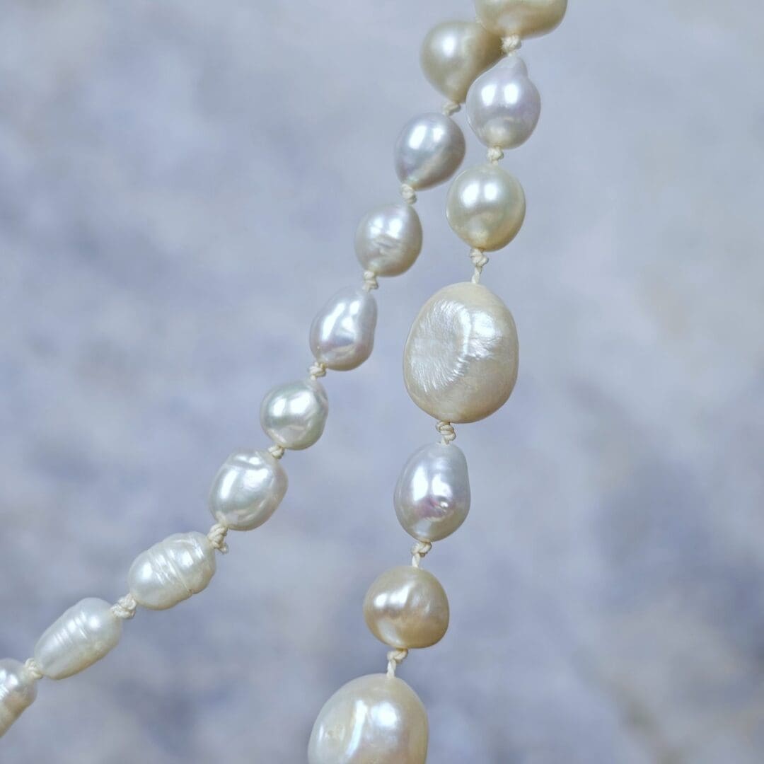 White baroque pearl necklace with a small etched silver heart pendant on a silk knotted strand, bead detail, Isobel Kelly Jewellery