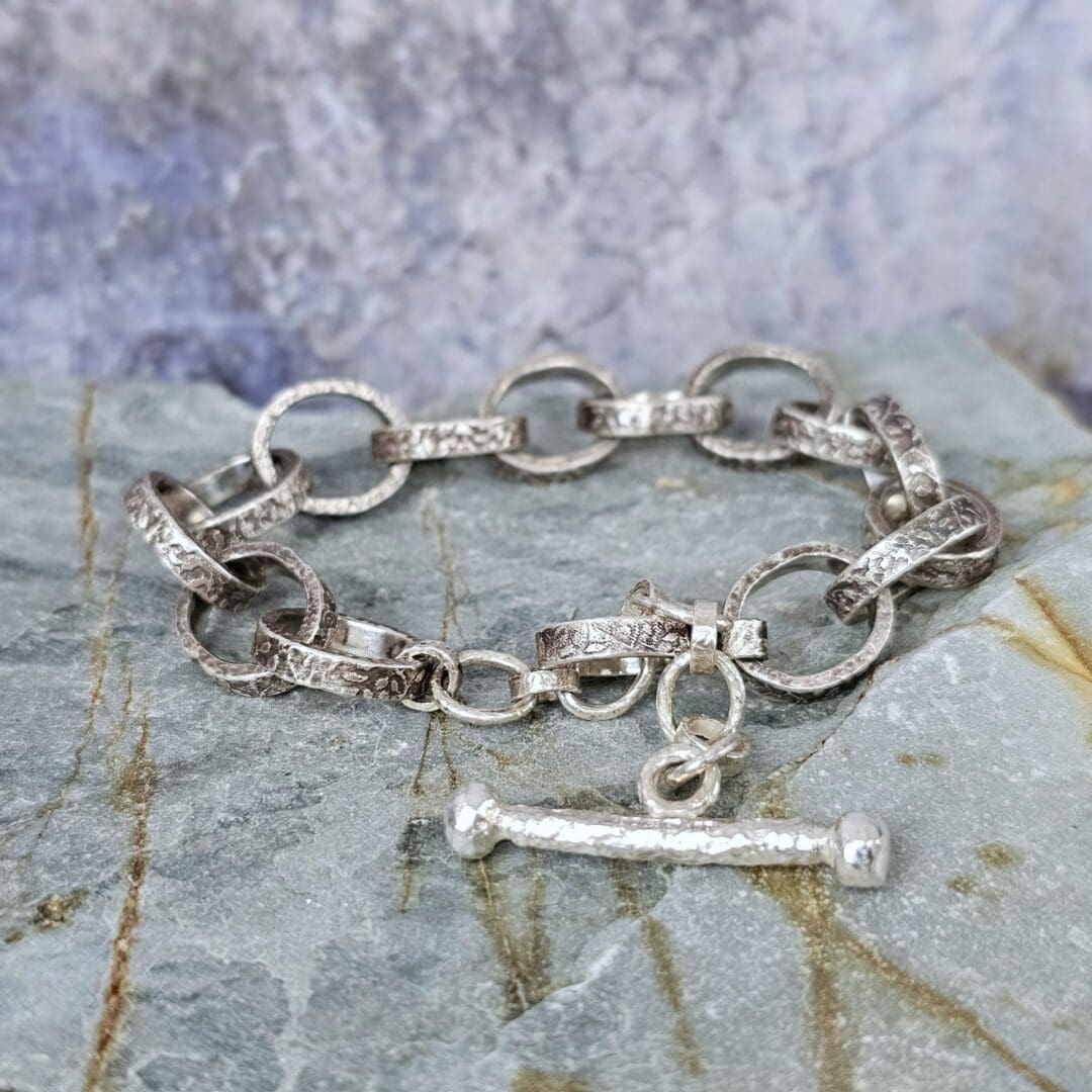 Chunky silver chain bracelet with hand etched leafy patterns and a forged toggle clasp, antique finish, Isobel Kelly Jewellery