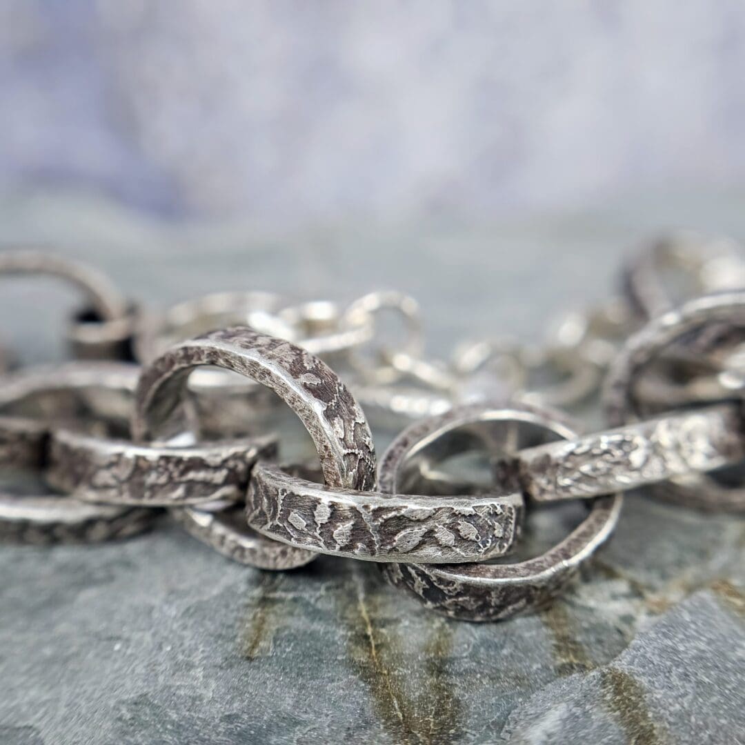 Chunky silver chain bracelet with hand etched leafy patterns and a forged toggle clasp, antique finish, link close up, Isobel Kelly Jewellery