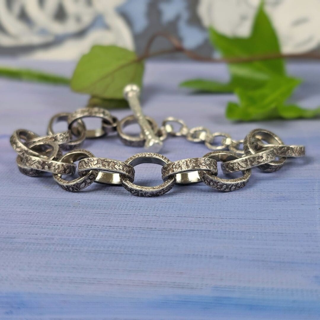 Chunky silver chain bracelet with hand etched leafy patterns and a forged toggle clasp, antique finish, Isobel Kelly Jewellery