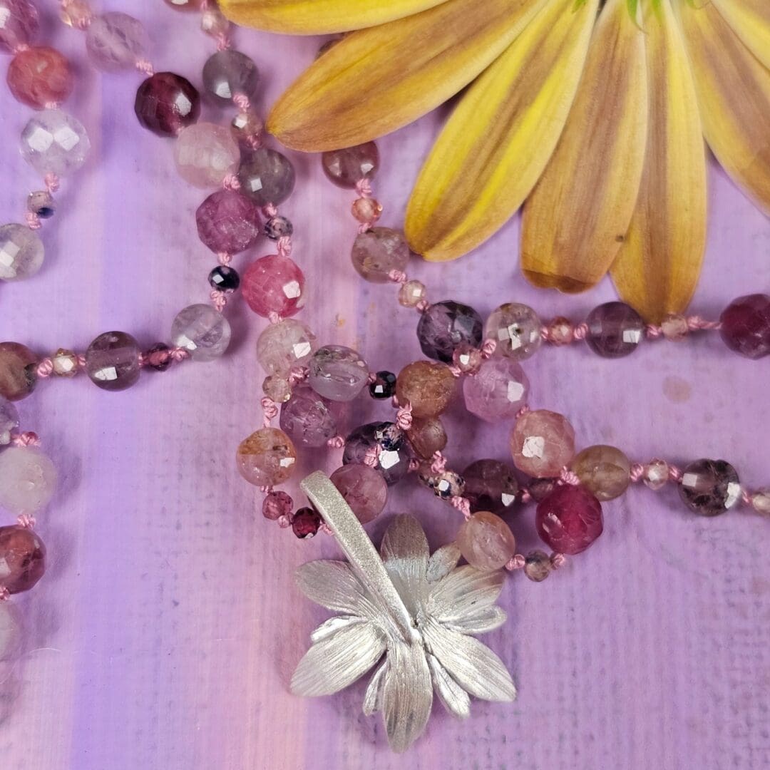 Spinel bead necklace with an etched silver flower pendant set with a small lab ruby at the centre, back of flower, Isobel Kelly Jewellery