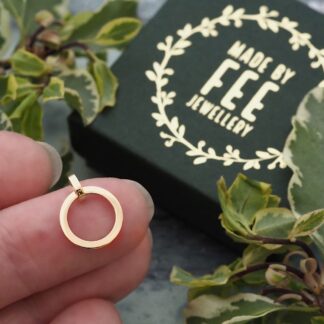 Handmade 9ct yellow gold open circle pendant shown on finger for scale