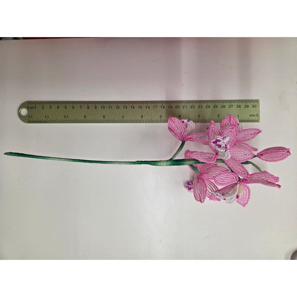Photo showing the 12 inch length of a pink french beaded orchid