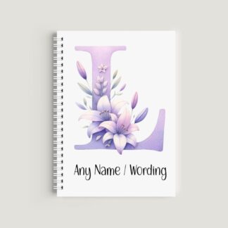 A spiral-bound notebook with a white cover. It features a large lilac watercolor letter "L" decorated with light purple lilies and buds. The bottom text reads "Any Name / Wording" in a clean black font.