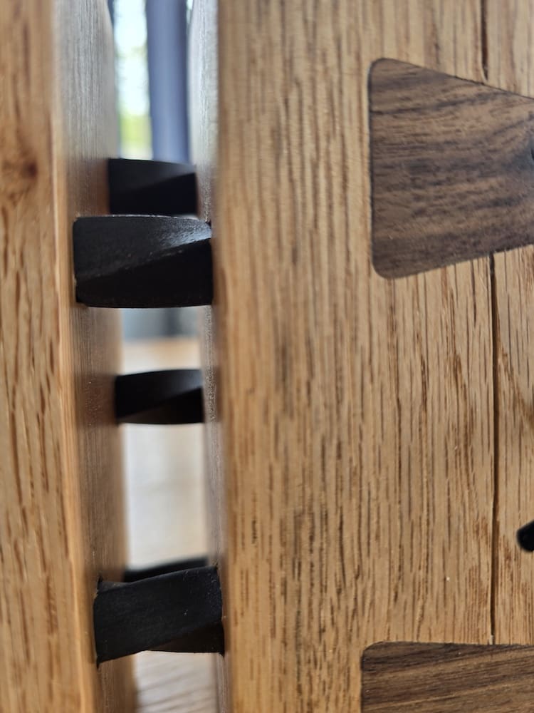 Solid oak clock with exposed steel rod structure side detail