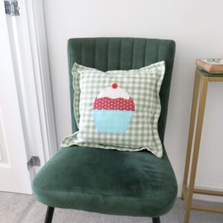 Green and white check cushion with an appliqued cupcake.
